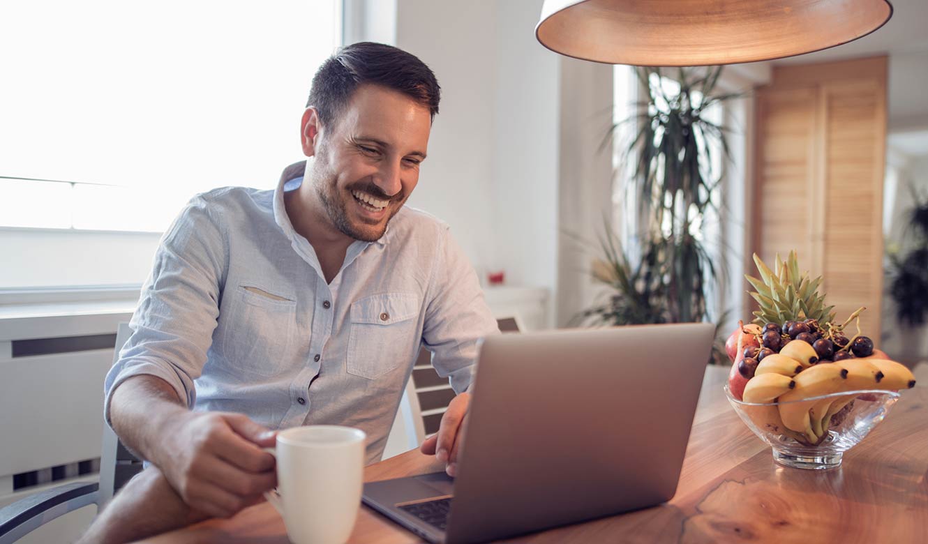 Man on a laptop in his kitchen