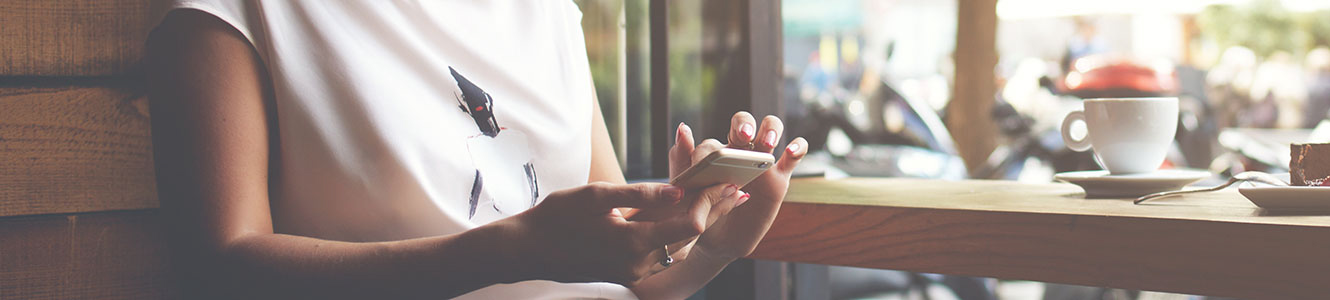 Lady with smartphone in a coffee shop